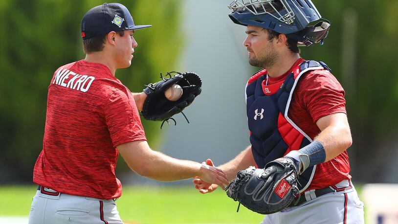 Braves top prospect catcher Shea Langeliers finishes a session working with pitcher J.J. Niekro, nephew of Braves legendary knuckleballer Phil Niekro, at the Braves' minor league spring training camp on Monday in North Port, Fla. (Curtis Compton / Curtis.Compton@ajc.com)