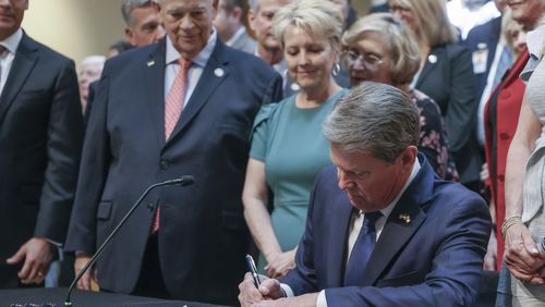 With much fanfare, Gov. Brian Kemp signs HB 1013, which aims to increase access to mental health coverage in Georgia on Sine Die, the last day of the General Assembly at the Georgia State Capitol in Atlanta on Monday, April 4, 2022.   (Bob Andres / robert.andres@ajc.com)