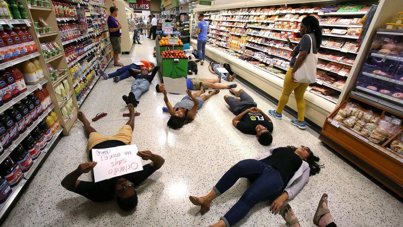 Demonstrators lay on the floor during a protest against gun violence inside a Publix store in Orlando, Fla, on May 25, 2018. (Joe Burbank/Orlando Sentinel/TNS)