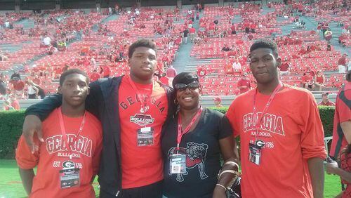 The recruiting sweepstakes for Trent Thompson took him all across the country. But his heart never left Georgia, which extended him his first offer as a high school junior. Thompson is pictured on a visit to UGA last fall with (left to right), brother Tyreck Thompson, mother Bridgette Flewellen and brother Trey Flewellen. (Special to AJC)