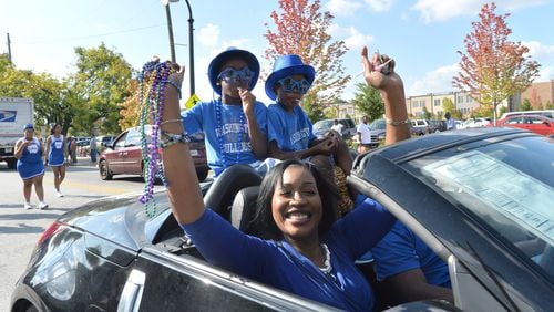 Booker T. Washington High School Principal Tasharah Wilson, shown here in a 2014 parade with her twin sons, plans to leave the high school to launch a new college and career academy. HYOSUB SHIN / HSHIN@AJC.COM