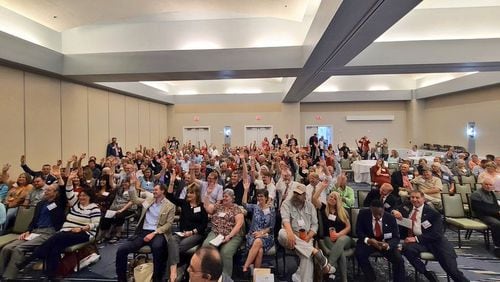 Newcomers to Georgia Republican meetings raise their hands during the 1st District GOP convention on May 15, 2021.