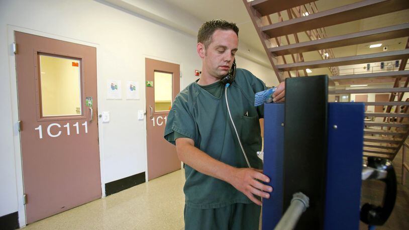 An inmate makes a phone call in the Gwinnett County Jail. JASON GETZ / JGETZ@AJC.COM