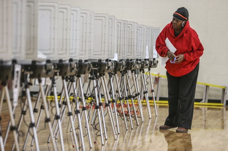 Poll worker Cathy Gray prepares the electronic machines for voting at Henry W. Grady High School in Atlanta in November. JOHN SPINK/JSPINK@AJC.COM