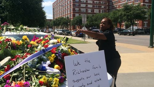 Dallas Police Det. Karen Lewis arranges flowers given in tribute to slain and injured officers. Photos: Jennifer Brett