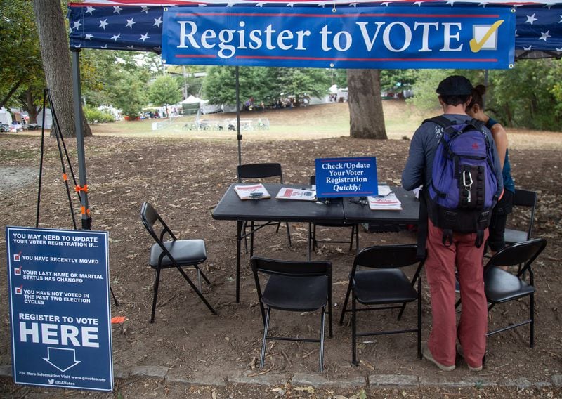 Greg Sawicki checks to make sure his voter registration is in order during this month’s Candler Park Fall Fest 2019 in Atlanta. STEVE SCHAEFER / SPECIAL TO THE AJC