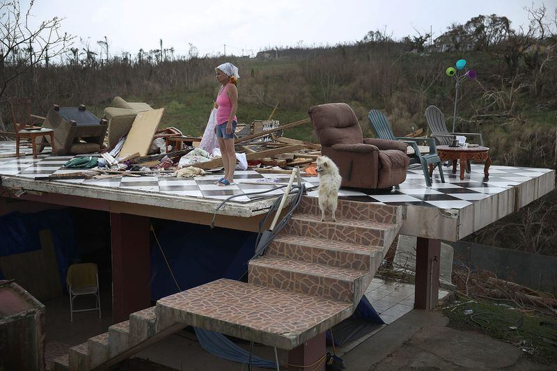With her parrot on her shoulder, Irma Maldanado and her dog stand in what is left of her home in Corozal. (Getty Images / Joe Raedle)