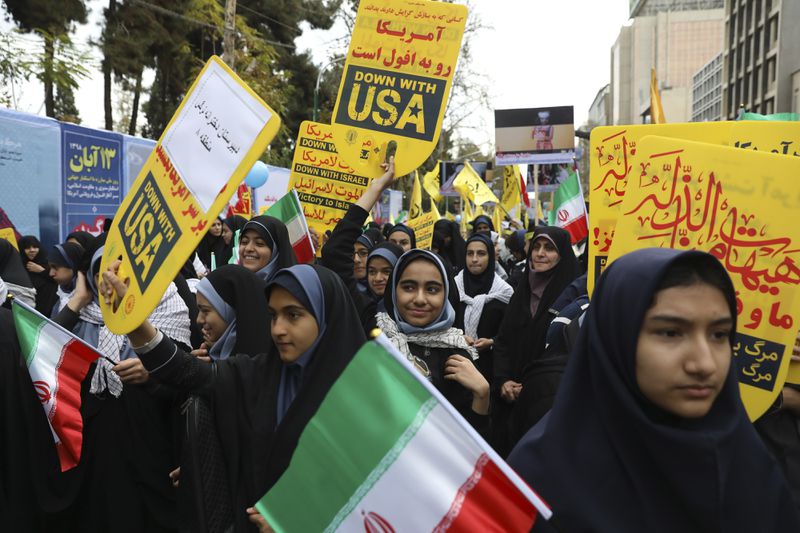 Iranian demonstrators chant slogans as they set fire to a representation of a makeshift U.S. flag during an annual rally in front of the former U.S. Embassy in Tehran, Iran, on Monday.
