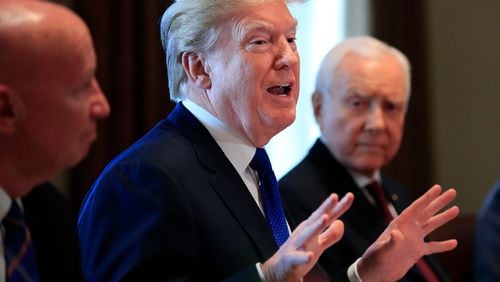 President Donald Trump, flanked by Rep. Kevin Brady, R-Texas, left, and Sen. Orrin Hatch, R-Utah, right, speaks during a bicameral meeting with lawmakers working on the tax cuts in the Cabinet Room of the White House in Washington, Wednesday, Dec. 13, 2017.