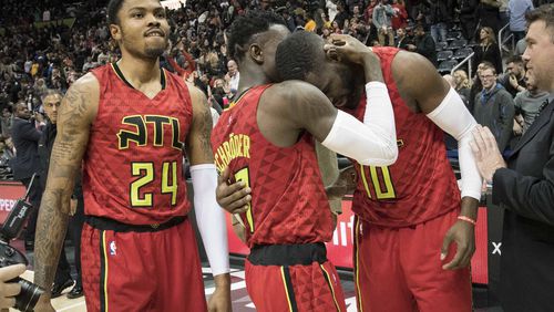 Atlanta Hawks guards Tim Hardaway Jr. (10) and Dennis Schroder congratulate each other as forward Kent Bazemore (24) watches after the team’s NBA basketball game against the San Antonio Spurs, Sunday, Jan. 1, 2017, in Atlanta. Atlanta won 114-112 in overtime. (AP Photo/John Amis)