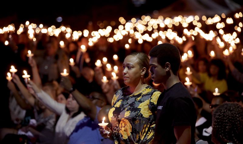 Veronica Hartfield, stands with her son, Ayzayah Hartfield during a candlelight vigil for her husband, Las Vegas police officer Charleston Hartfield, Thursday, Oct. 5, 2017, in Las Vegas. Hartfield was killed during the Sunday night shooting at the Route 91 Harvest country music festival. Gregory Bull/Associated Press