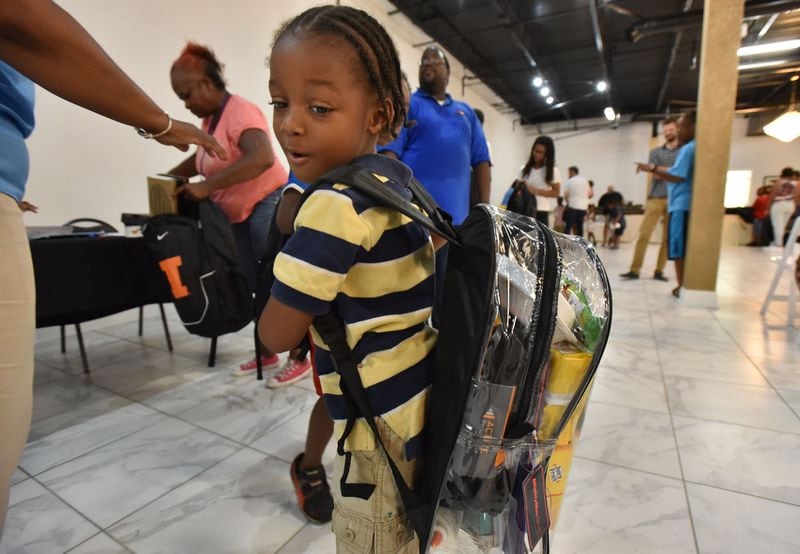 July 15, 2017 Atlanta - Jacques Thomas, 4, turns his head to check his school supplies inside a clear backpack during No Bare Soles Annual Shoe Distribution at Caring For OthersÛª headquarters on Saturday, July 15, 2017. Atlanta-based human services agency Caring For Others hosted annual No Bare Soles Shoes Distribution at their headquarters. More than 250 pairs of brand new shoes were given to local children. School supplies and book bags were also distributed during the event. For the first time, this event took place during summer, making it the perfect opportunity for local kids to get a free pair of brand new back-to-school shoes. HYOSUB SHIN / HSHIN@AJC.COM