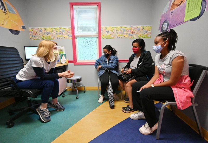  Dr. Debby Pollack (left) talks to Miriam Araya (right), 15, and her mother Betty Kidanu and sister Melina  Araya, 11, after Miriam received a first dose of the Pfizer-BioNTech vaccine at Dekalb Pediatric Center. (Hyosub Shin / Hyosub.Shin@ajc.com)