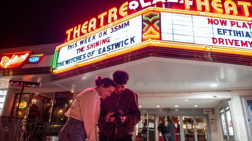 Yesenia Cerezo and Joel Manrique look over photos they just shot in front of the Plaza Theatre marque Saturday night, Jan. 29, 2022.  Ben Gray for the Atlanta Journal-Constitution
