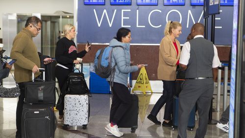 Travelers approach the terminal south security checkpoint in the Hartsfield-Jackson international airport on Monday, December 12, 2022. AAA predicts a busy travel season during the holidays. CHRISTINA MATACOTTA FOR THE ATLANTA JOURNAL-CONSTITUTION