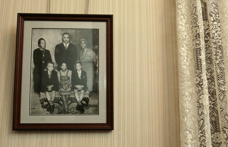 A family photo hangs in the entryway of Martin Luther King Jr.'s childhood home. It includes (clockwise from top left) Alberta Williams King, the Rev. Martin Luther King Sr., Jennie Williams, Alberta's mother, and the three King children, A.D. (Alfred Daniel), Christine and Martin Jr. (AJC file photo / Jessica McGowan)