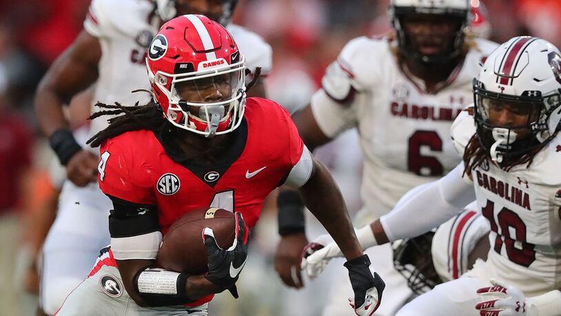Georgia running back James Cook (4) breaks through South Carolina defenders on a touchdown run during the first quarter at Sanford Stadium on Saturday, Sept 18, 2021, in Athens, Ga. (Curtis Compton/Atlanta Journal-Constitution/TNS)