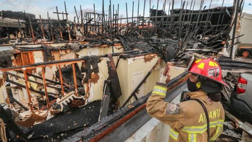 Atlanta Fire Rescue Capt. Norris Gresham looks for hot spots after a massive apartment fire in Buckhead last week.