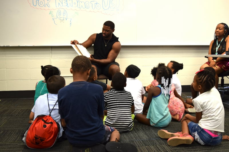 Georgia Tech lineman KeShun Freeman reads to rising third graders who attend the Horizons Atlanta summer learning program that supports students from underserved communities throughout their K–12 academic careers.