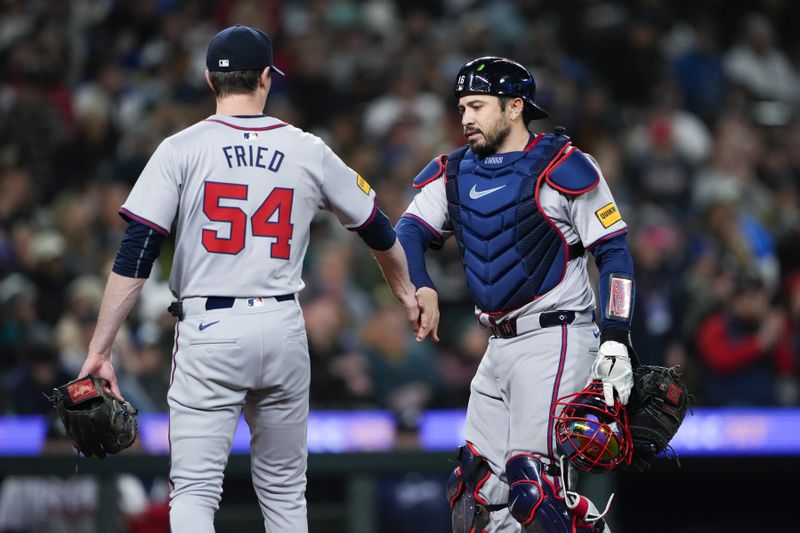 Atlanta Braves starting pitcher Max Fried (54) is greeted by catcher Travis d'Arnaud, right, after throwing out Seattle Mariners' Luis Urías at first base to end the fifth inning of a baseball game Monday, April 29, 2024, in Seattle. (AP Photo/Lindsey Wasson)