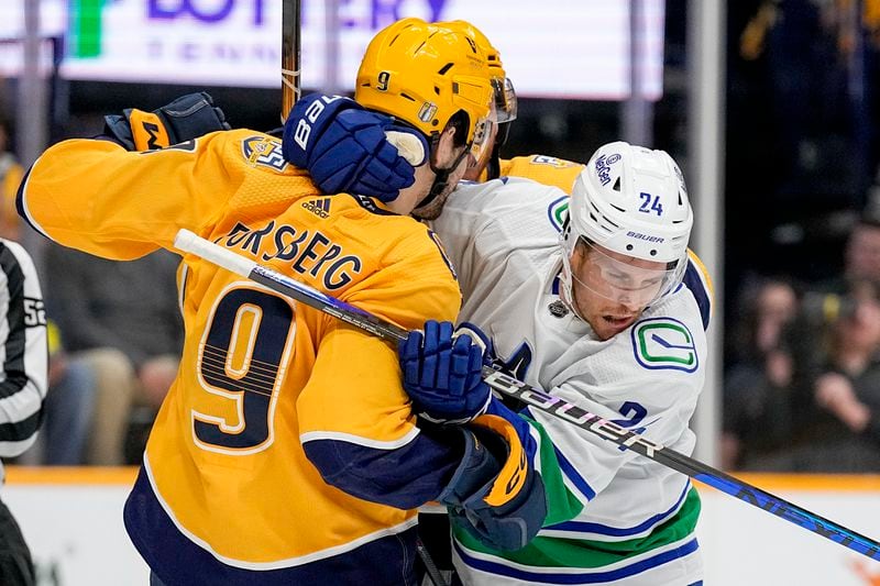 Nashville Predators left wing Filip Forsberg (9) and Vancouver Canucks center Pius Suter (24) get into a scuffle during the first period in Game 6 of an NHL hockey Stanley Cup first-round playoff series Friday, May 3, 2024, in Nashville, Tenn. (AP Photo/George Walker IV)