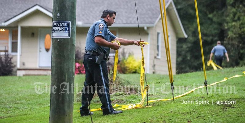 A police officer places crime scene tape at a home on Prospect Church Road after a woman was shot and killed on Monday morning.