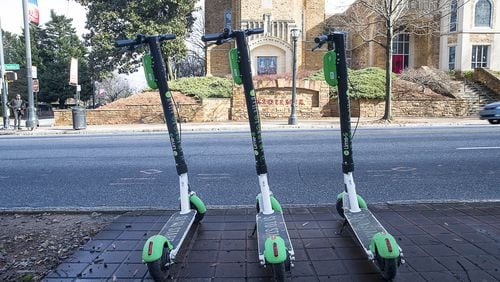 Lime scooters sit parked on the sidewalk on Peachtree Street in Atlanta. (ALYSSA POINTER/ALYSSA.POINTER@AJC.COM)