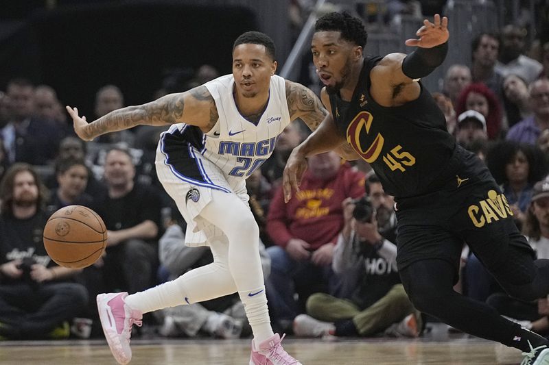Orlando Magic guard Markelle Fultz (20) and Cleveland Cavaliers guard Donovan Mitchel (45) watch the ball in the first half of Game 7 of an NBA basketball first-round playoff series Sunday, May 5, 2024, in Cleveland. (AP Photo/Sue Ogrocki)