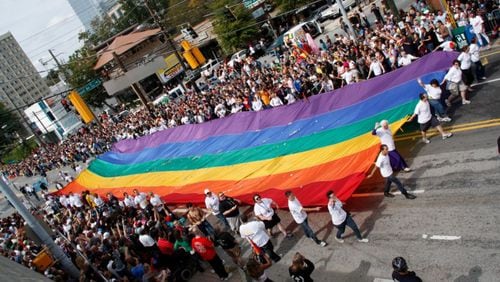 Unfurling a symbol of pride: Marchers in Pride 2011 carry a massive rainbow flag through Midtown Atlanta. Credit: Henry Etsitty