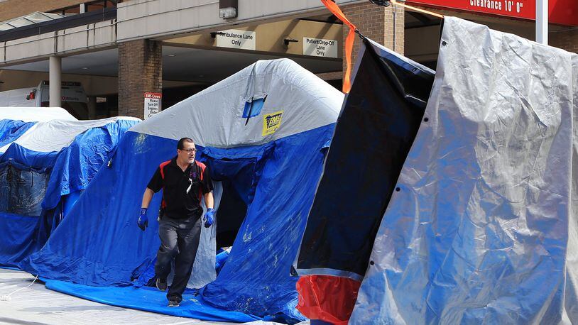 Workers set up tents in front of a hospital emergency room on March 27, 2020, in Marietta, which is among the medical centers treating coronavirus patients. (Christina Matacotta, for The Atlanta Journal-Constitution)