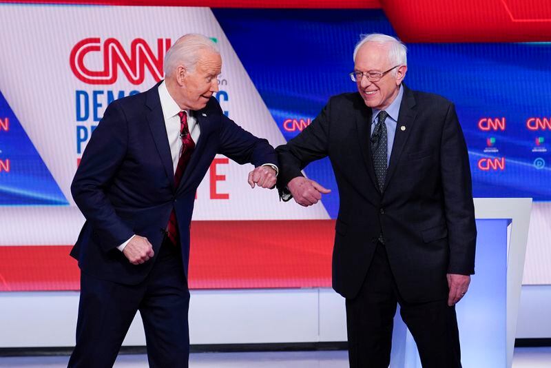 FILE - Former Vice President Joe Biden, left, and Sen. Bernie Sanders, I-Vt., right, greet one another before they participate in a Democratic presidential primary debate at CNN Studios in Washington, March 15, 2020. (AP Photo/Evan Vucci, File)