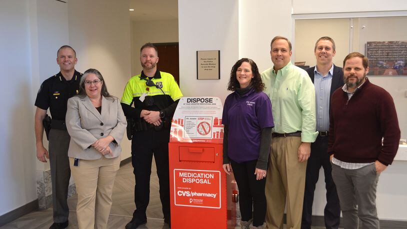 Johns Creek Mayor John Bradberry, Mayor Pro Tem Chris Coughlin, Johns Creek Police Department Chief Mark Mitchell, police officers, city staff, and One Johns Creek Coalition members gathered recently to mark the placement of the Drug-Drop-Box at city hall. (Courtesy City of Johns Creek)