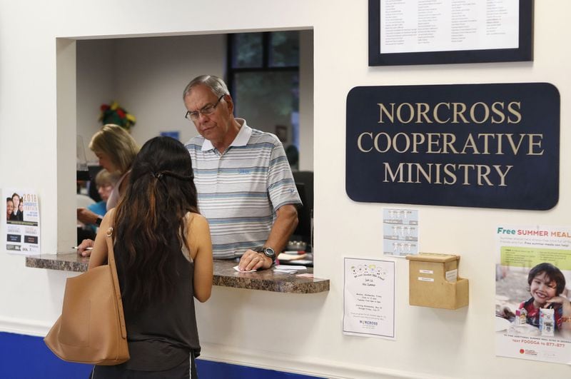 Tom Fishburne. a volunteer and board member, helps a client at Norcross Cooperative Ministry, one of the busiest co-ops in Gwinnett County, on July 13, 2018. BOB ANDRES /BANDRES@AJC.COM
