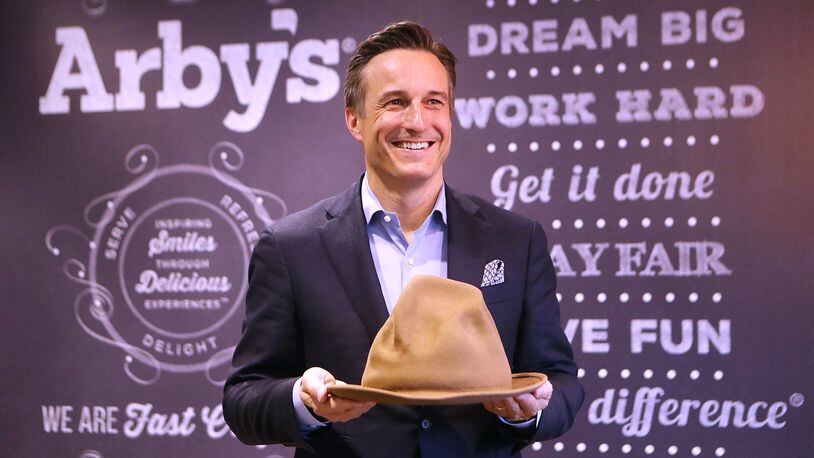 Arby’s CEO Paul Brown, holding a hat Pharrell Williams wore during the 2014 Grammy Awards, says playful products and marketing have paid off for the Atlanta fast-food chain. The hat, which Arby’s bought for $49,000, resembles Arby’s logo. Curtis Compton/ccompton@ajc.com