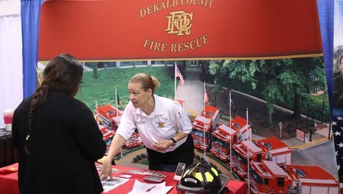 DeKalb County Fire youth development administrator Annette Haygood, facing, talks with a potential recruit during the 15th Annual Jobs Fair at the Georgia International Convention Center Friday. JASON GETZ for the AJC
