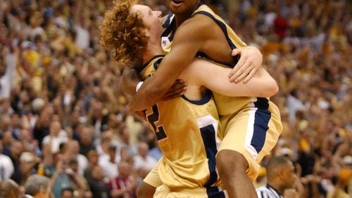 040403 - SAN ANTONIO, TX -- Georgia Tech's Luke Schenscher (cq, 12), center, hugs teammate Marvin Lewis (cq, 24), right-top, after defeating Oklahoma State at the 2004 NCAA Final Four at the Alamodome Saturday evening, April 3, 2004 . Georgia Tech won 67 to 65. (SUNNY SUNG/AJC staff)