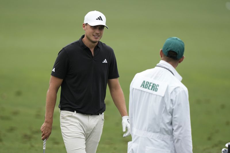 Ludvig Aberg, of Sweden, talks with his caddie on the driving range during a practice round in preparation for the Masters golf tournament at Augusta National Golf Club Tuesday, April 9, 2024, in Augusta, Ga. (AP Photo/Charlie Riedel)