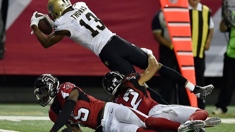 Saints wide receiver Michael Thomas (13) jumps into the end zone over two Falcons defenders in the second half of the final regular season game at the Georgia Dome against the Saints Sunday, Jan.1, 2017, in Atlanta.