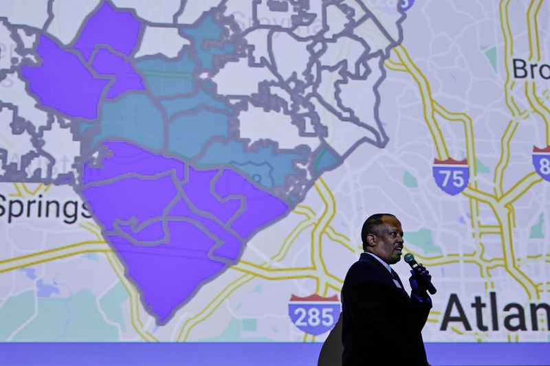 State Rep. David Wilkerson speaks during a town hall discussion about the process to de-annex from the city on Wednesday, January 18, 2023. The cityhood election results are shown on a map, with green representing precincts that voted "no," and blue representing "yes." (Natrice Miller/natrice.miller@ajc.com) 
