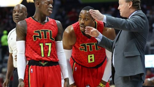 Hawks center Dwight Howard and guard Dennis Schroder confer with head coach Mike Budenholzer during a 107-92 loss to the Brooklyn Nets for their seventh consecutive loss in a NBA basketball game on Sunday, March 26, 2017, in Atlanta. Curtis Compton/ccompton@ajc.com
