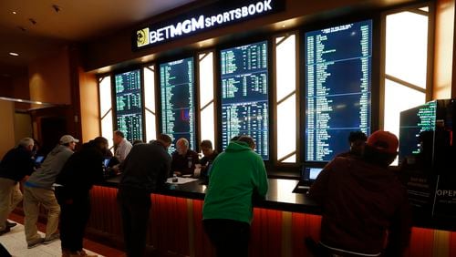 Gamblers place bets during the launch of legalized sports betting in Michigan at the MGM Grand Detroit casino in Detroit, Wednesday, March 11, 2020. As the bright lights of sports betting have gone dim, gamblers have been forced to find some imaginative alternatives.