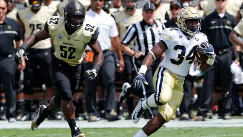Georgia Tech running back Marcus Marshall (34) runs away from Vanderbilt linebacker Nigel Bowden (52) to score a touch down on a pass from quarterback Justin Thomas in the first half of an NCAA college football game Saturday, Sept. 17, 2016, in Atlanta. (AP Photo/John Bazemore)