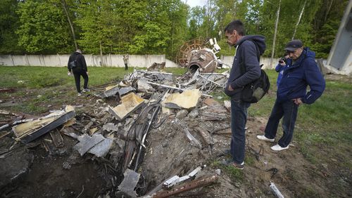 People look at fragments of the television tower which was broken in half after it was hit by a Russian missile in Kharkiv, Ukraine, Monday, April 22, 2024. (AP Photo/Andrii Marienko)