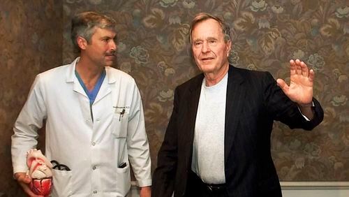 Former President George H.W. Bush waves with his cardiologist, Mark Hausknecht, after a news conference in Houston in 2000. Hausknecht was shot and killed by a fellow bicyclist Friday, July 20, 2018, while riding through a Houston medical complex.