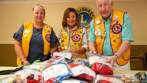 Missy Braden (from left), Doreen Stallworth, Richard Brown fill “PJ Packs” with new PJs, underwear and socks during a meeting of the Georgia Lions Club in Covington. Stallworth came up with a service project of giving “PJ Packs” to hospitalized children at Children’s Healthcare of Atlanta. (Photo by Phil Skinner)