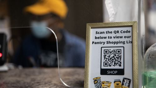 A scannable QR code sits on the pantry’s front desk on Tuesday, Aug. 17, 2021, allowing students to digitally view the pantry’s shopping list. The Kennesaw State University food pantry relocated to the Carmichael Student Center in February 2021, allowing the pantry to serve more students with an expanded selection of items. (Photo/Ryan Cameron for the Atlanta Journal Constitution) 