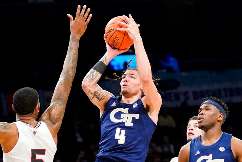 Georgia Tech's Jordan Usher (4) shoots over Louisville's Malik Williams, left, during the first half of an NCAA college basketball game of the Atlantic Coast Conference men's tournament, Tuesday, March 8, 2022, in New York. (AP Photo/John Minchillo)