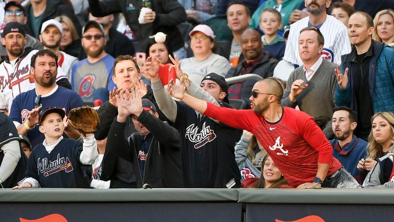 Braves fans reach for a foul ball at a game early this season.