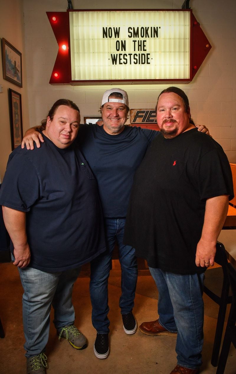 Twins Justin (left) and Jonathan Fox (right) and their longtime friend and partner Beau Nolen (center) are shown at the new location of Fox Bros. Bar-B-Q at The Works on Atlanta’s Upper Westside. (Chris Hunt for The Atlanta Journal-Constitution)