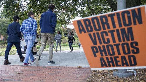 Students walk past graphic abortion photographs during a Cerated Equal organizational event at Georgia Tech’s campus in Atlanta on Monday. The Created Equal organization visited the campus with large photographs and video of aborted fetuses.